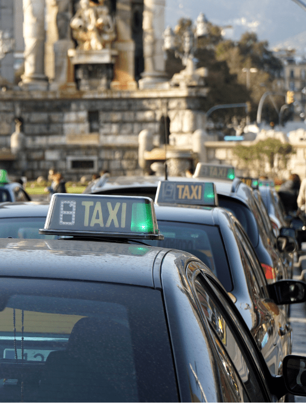 Fila de taxis en Barcelona listos para llevar pasajeros a La Roca Village, ofreciendo un servicio de transporte cómodo y eficiente.